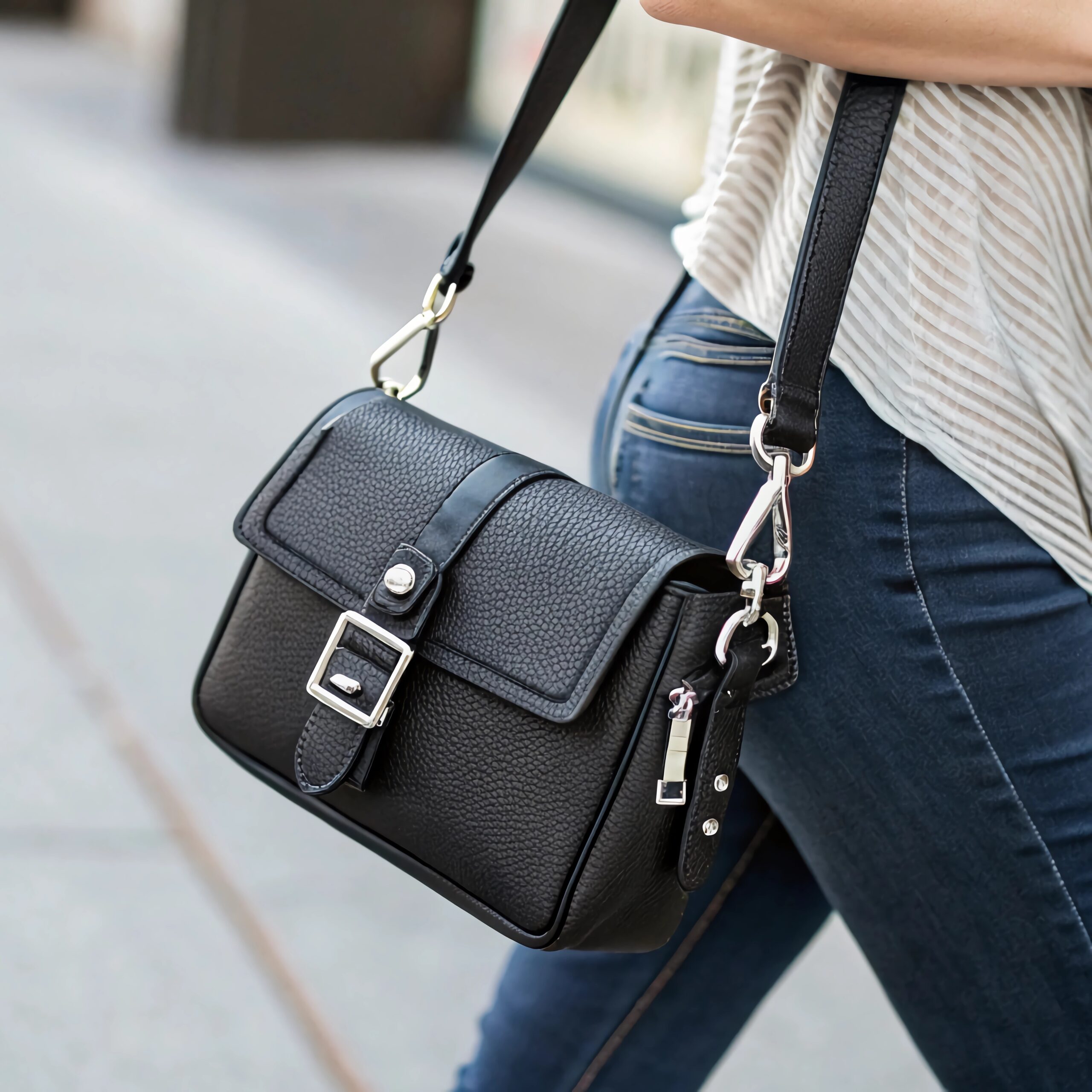 A close-up of a trendy black crossbody bag with a sleek design